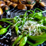 Bärlauch-Stängel in Butter mit Parmesan - und gebratenen Champignons im Hintergrund