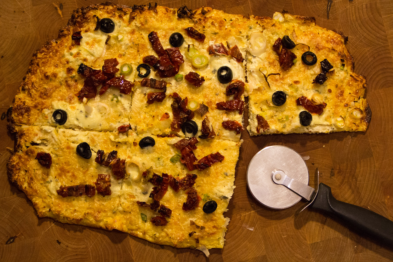 Karfiol Flammkuchen mit Oliven, Frühlingszwiebel und getrockneten Tomaten