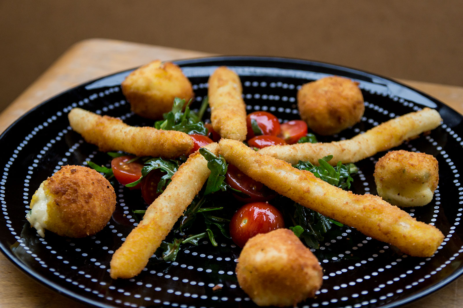 Panierte Spargelspitzen und Mozzarellabällchen auf Tomaten-Rucolasalat